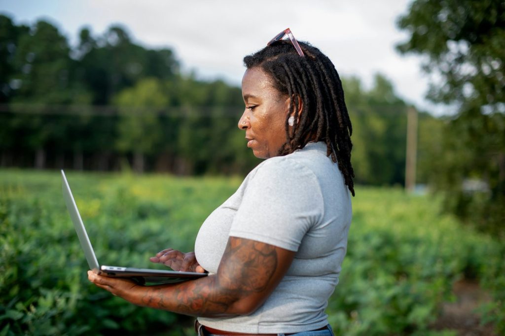 Woman on her laptop with field in background